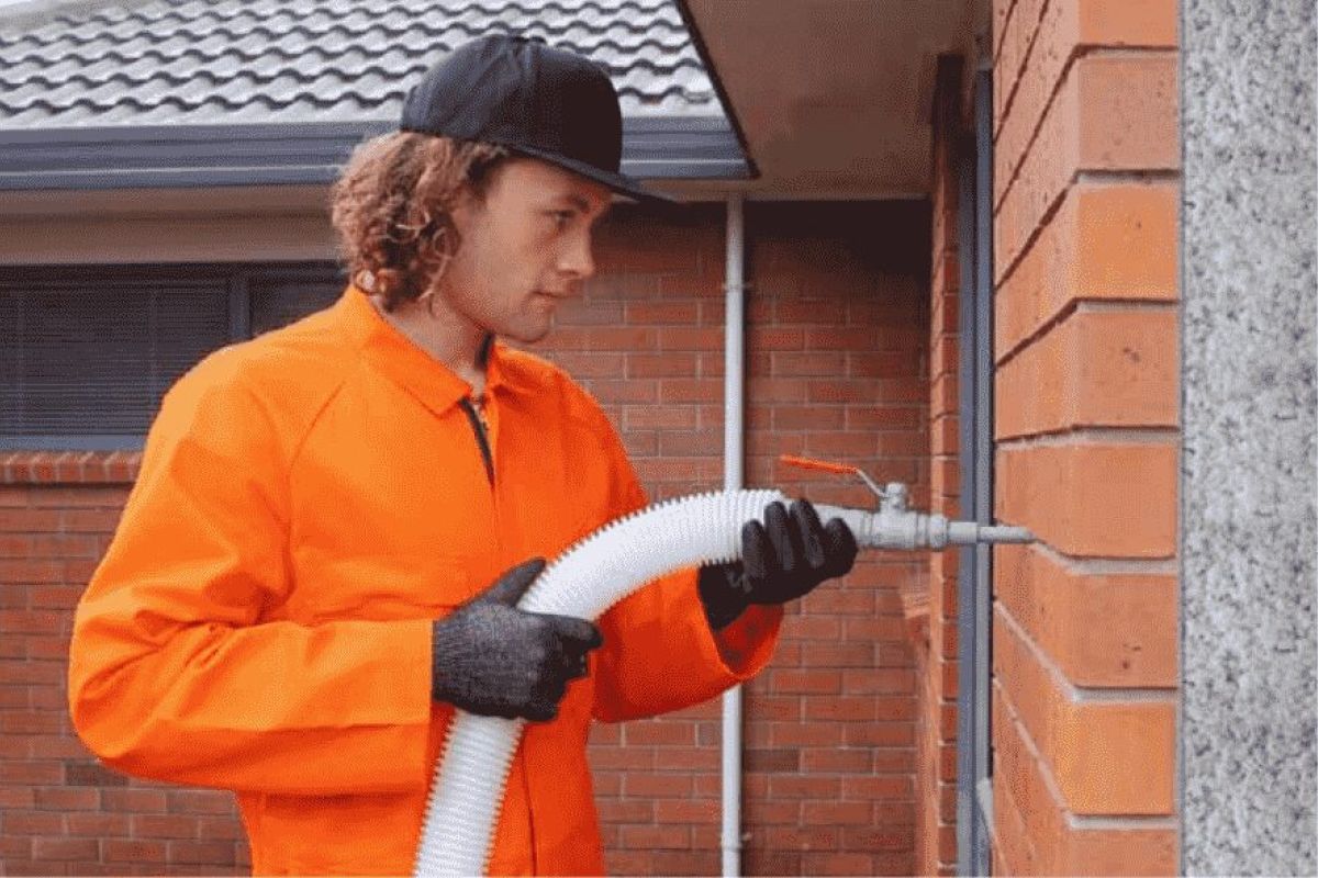 Man insulating external wall with brick cladding